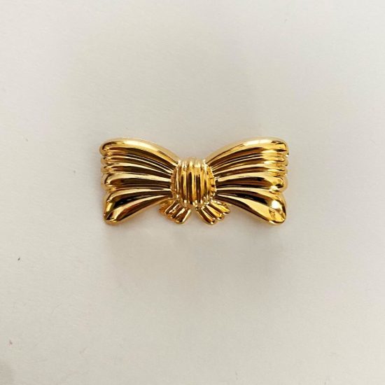 Broche dorado con forma de lazo. Broche dorado para flamenca con forma de moña. Broche dorado flamenca.